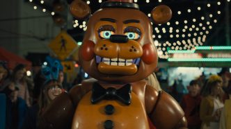Freddy Fazbear and the animatronics looming in a dark hallway in Five Nights at Freddy’s 2, showcasing the sequel’s improved game-accurate design and atmosphere