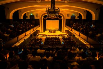 Candlelight concert performance with string musicians surrounded by candles in an intimate venue