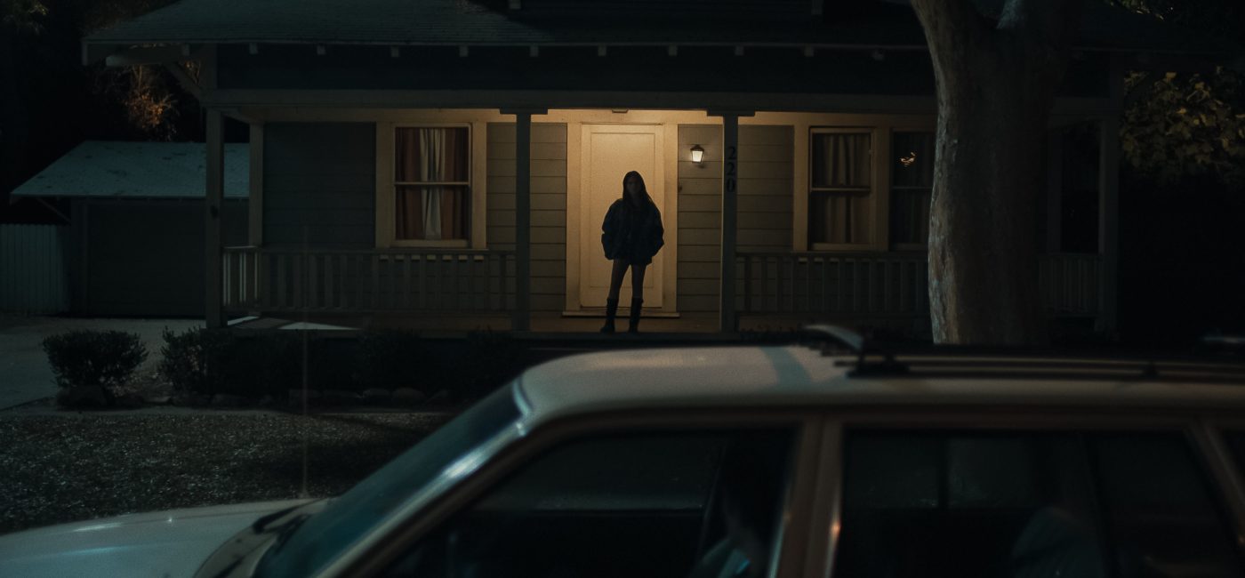Inde Navarrette as Nikki in Obsession (2026) shown in dark shadow lighting with an intense, obsessive expression