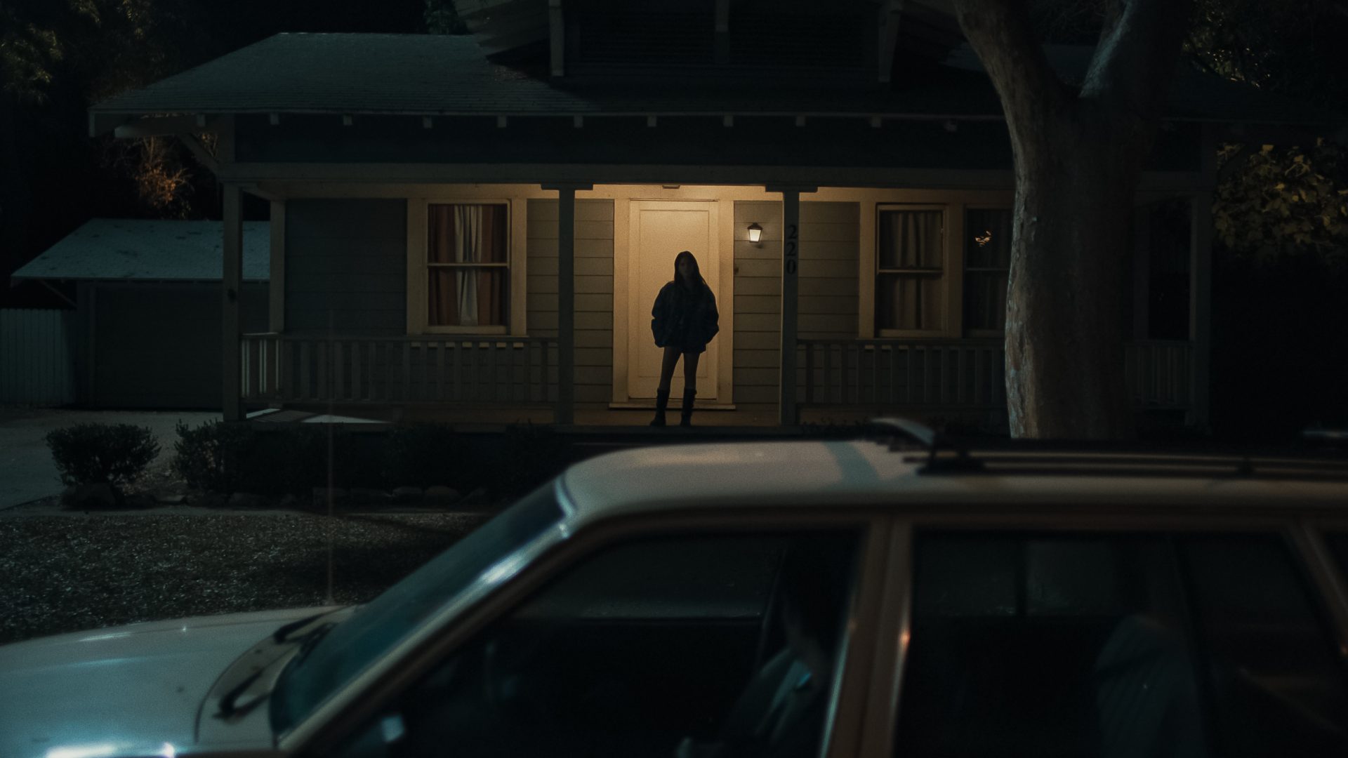 Inde Navarrette as Nikki in Obsession (2026) shown in dark shadow lighting with an intense, obsessive expression