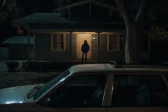 Inde Navarrette as Nikki in Obsession (2026) shown in dark shadow lighting with an intense, obsessive expression